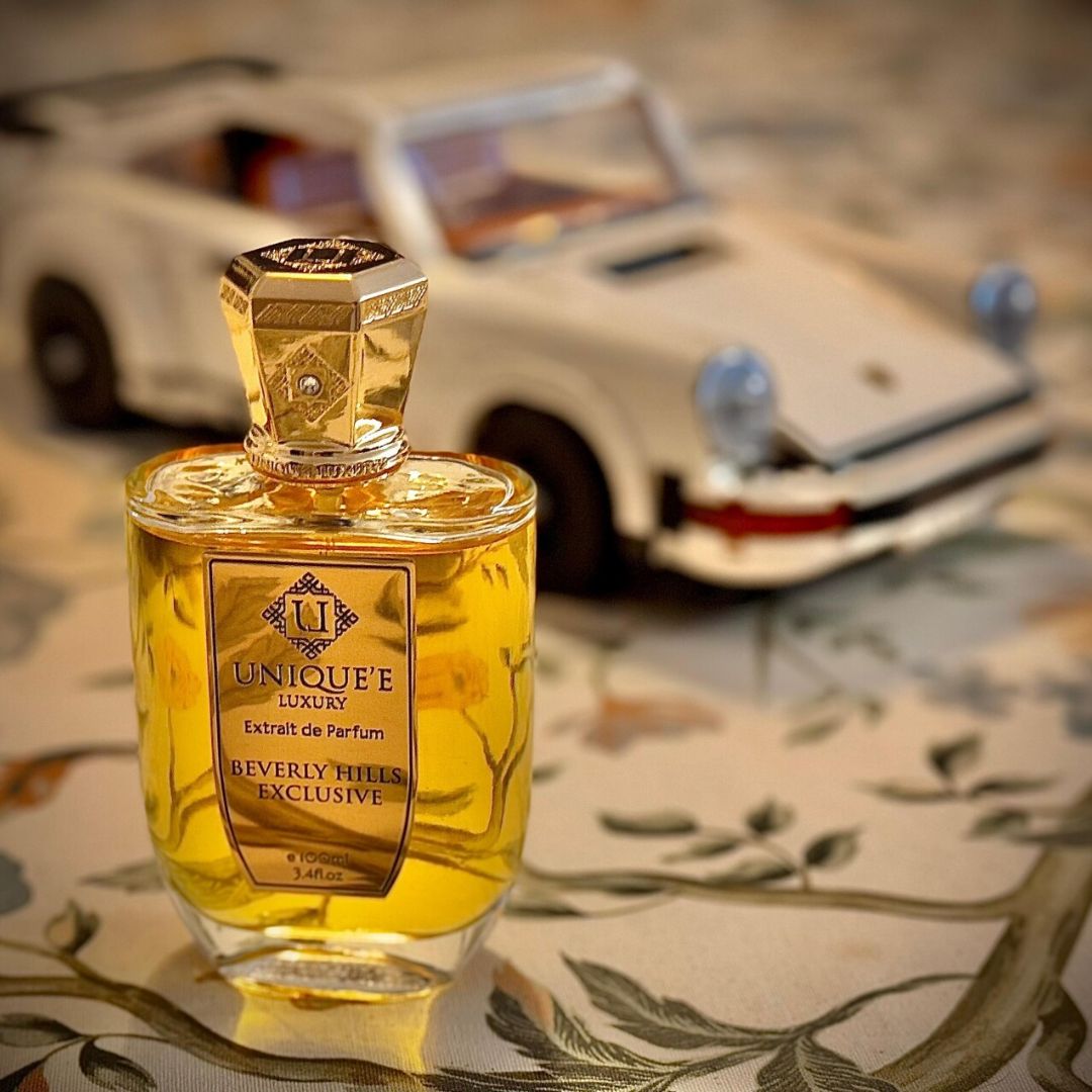 Beverly Hills Exclusive Extrait de Parfum 100ml by Unique'e Luxury, elegant glass bottle with gold accents and black cap.